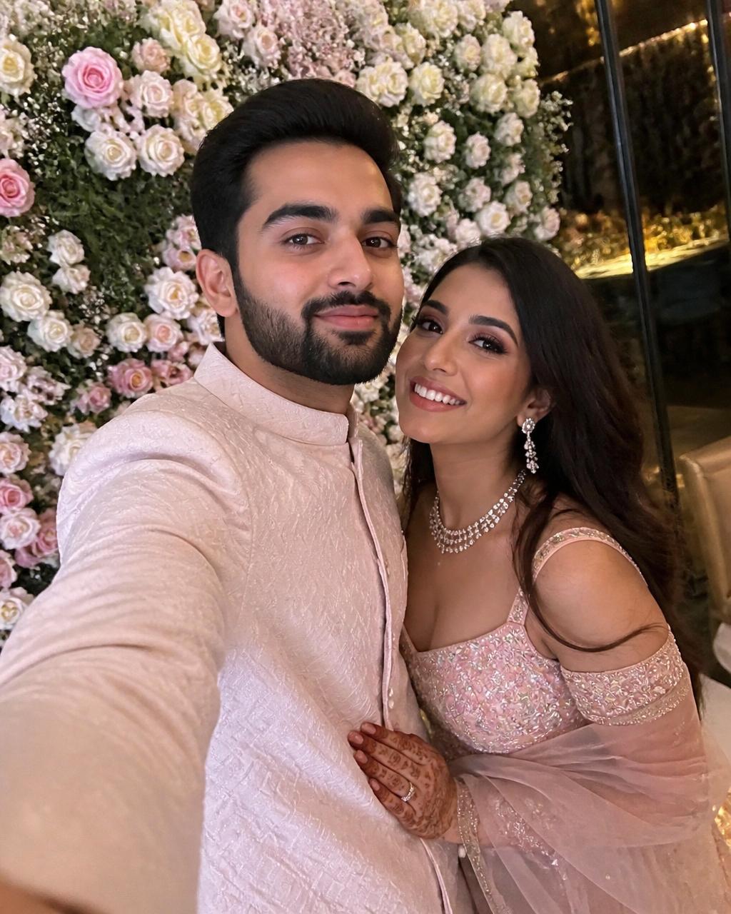 Engagement selfie in front of a floral wall